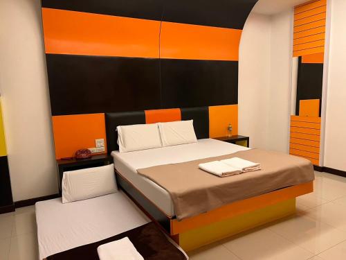 a bedroom with a bed with an orange and black headboard at Hi-End Sriracha Resort & Hotel in Ban Nong I Bu