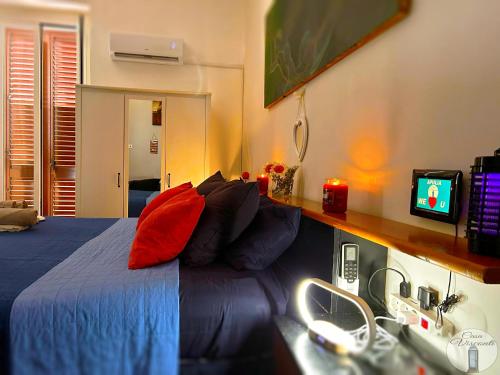 sypialnia z niebieskim łóżkiem z czerwonymi poduszkami w obiekcie Casa Visconti w mieście Bari