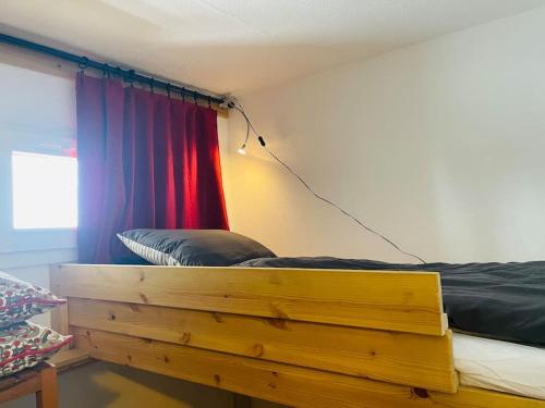 a bed with a wooden frame in a room at Ski apartment 3 valleys in Les Menuires