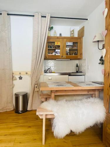a room with a desk with a white furry rug at Ski apartment 3 valleys in Les Menuires