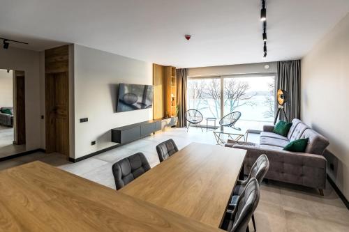 ein Wohnzimmer mit einem Tisch und einem Sofa in der Unterkunft Apartamenty Stranda Residence nad jeziorem Mazury Holiday in Giżycko