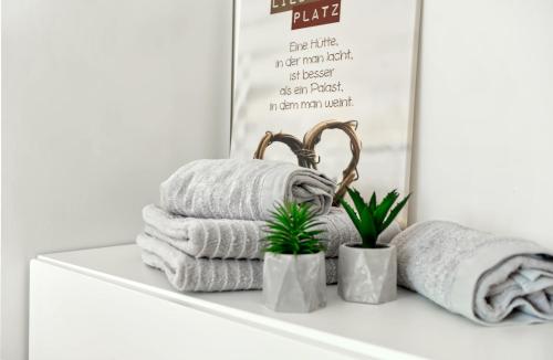 a shelf with towels and plants in front of a mirror at Modern Wohnen I Smart TV I Terrasse I 2x Parkplatz I 2 Schlafzimmer I 6 Schlafplätze in Bad Oeynhausen