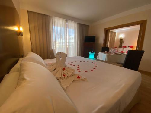a hotel room with a white bed with flowers on it at Hotel Montera Plaza in Los Barrios