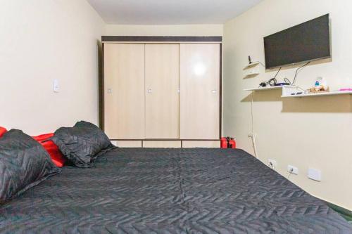 a bedroom with a large bed and a tv at Apartamento Encantador II - Enseada Guarujá - 100 metros da Praia in Guarujá