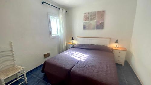 Un dormitorio con una cama y una silla y una ventana. en VILLA MAR, en Calafat