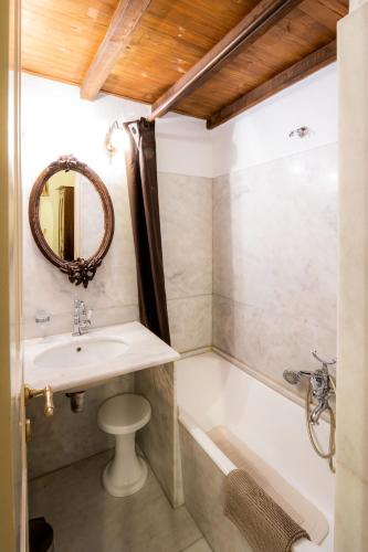 a bathroom with a sink and a bath tub at Archontiko Naoumidi in Portariá