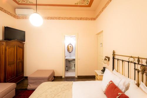 a bedroom with a bed and a television and a bathroom at Archontiko Naoumidi in Portariá