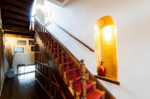 a staircase in a house with a wooden railing at Archontiko Naoumidi in Portariá