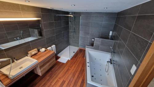 uma casa de banho com uma banheira, um lavatório e um chuveiro em Royal Hotel-Restaurant Bonhomme em Sougné-Remouchamps