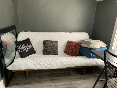 a white couch with pillows on it in a room at Maryland Homestay in Winnpeg downtown in Winnipeg