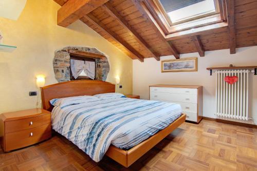 a bedroom with a large bed and a skylight at La Mansarda di Eros e Tiziana in Lanzo dʼIntelvi