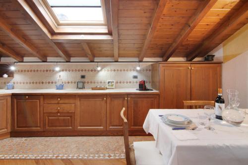 cocina con armarios de madera, mesa y ventana en La Mansarda di Eros e Tiziana, en Lanzo d'Intelvi