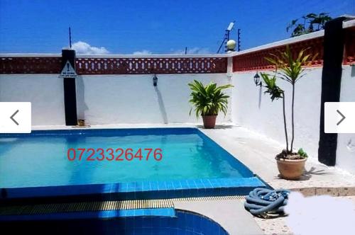 a swimming pool in front of a house at Mombasa Shanzu One Bedroom Apartment /Swimming Pool/Free WiFi in Mombasa