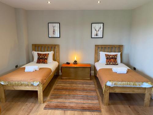a bedroom with two beds and a table and a lamp at The Cart House in York