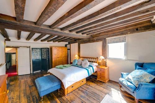 a bedroom with a large bed and a blue chair at Flushing House, Rye in Rye
