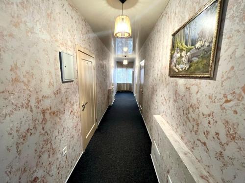 a hallway with a painting on the wall and a hallwayngthngthngthngthngth at Viktan Hotel in Bukovel