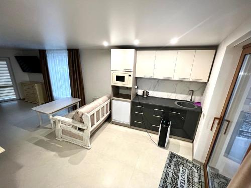 a small kitchen with white cabinets and a table at Viktan Hotel in Bukovel