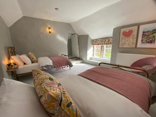 a bedroom with two beds and a couch at Jacks Cottage, Curbar in Curbar