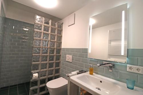 a bathroom with a sink and a toilet and a mirror at S12 - Boardinghouse by Hotel Trezor in Singen
