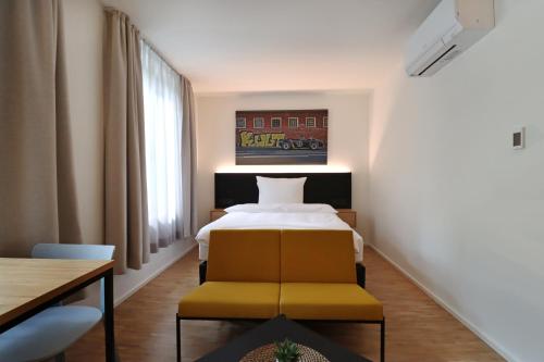 a bedroom with a bed and a table and a chair at S12 - Boardinghouse by Hotel Trezor in Singen