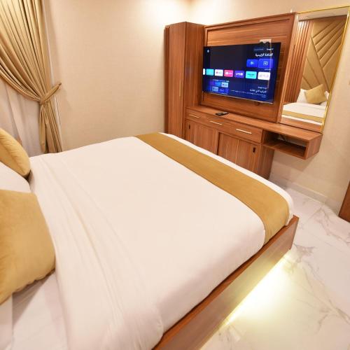 a hotel room with a bed and a television at الدانة للشقق الفندقية in Kuwait