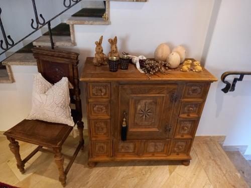 a wooden cabinet and a chair next to a staircase at Hotel Garni Erler in Mayrhofen