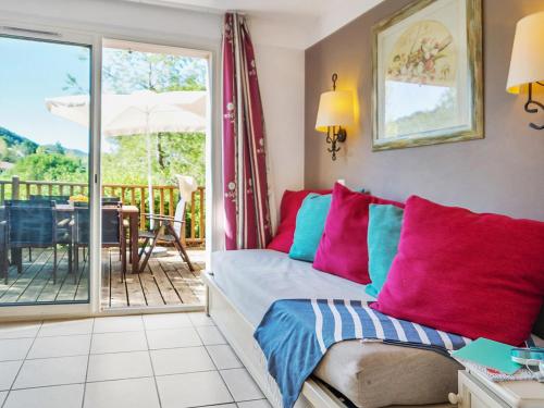 a living room with a bed and a balcony at Village Pierre & Vacances Le Rouret in Grospierres