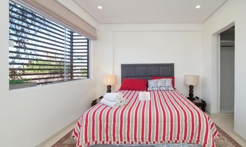 a bedroom with a large bed with red and white sheets at N3A1 - New, Nice, for Long and Short Stay in Asunción