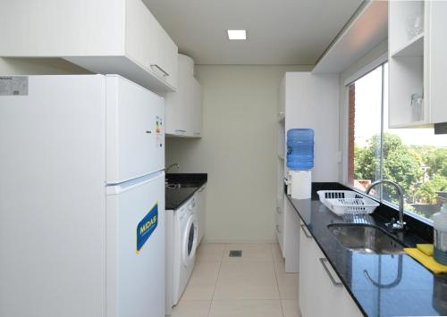 a white kitchen with a sink and a refrigerator at N3A1 - New, Nice, for Long and Short Stay in Asuncion