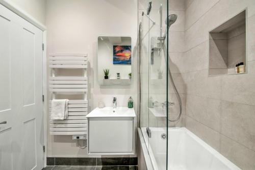 uma casa de banho branca com um chuveiro e um lavatório. em Finest Retreats - Market View em Ripon