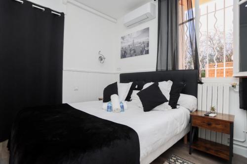 a black and white bedroom with a bed and a window at Hostellerie LE PANEL in Mandelieu-La Napoule