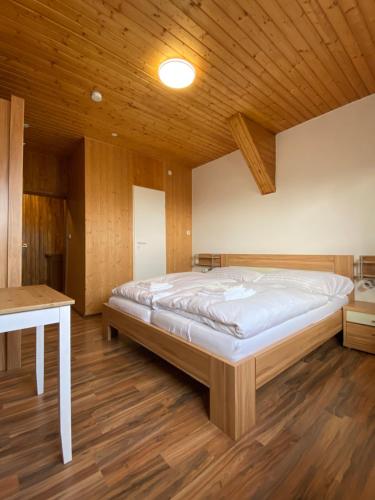 Gasthaus zum Ochsen في Herrischried: سرير كبير في غرفة ذات سقف خشبي