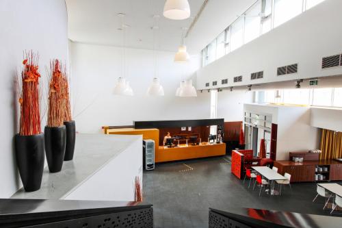 a dining room with tables and chairs and a kitchen at Kyriad Vienna Altmannsdorf in Vienna