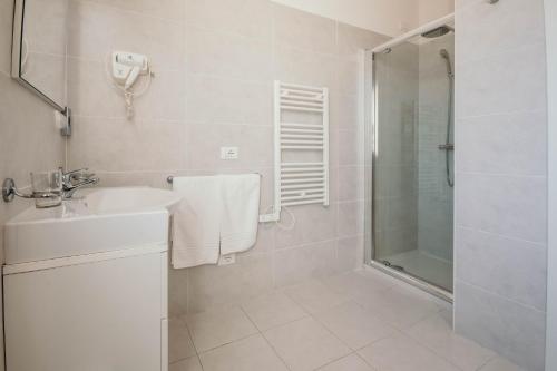 uma casa de banho branca com um chuveiro e um lavatório. em AL 13 Rosso - Lakeside Leisure & Business em Stresa