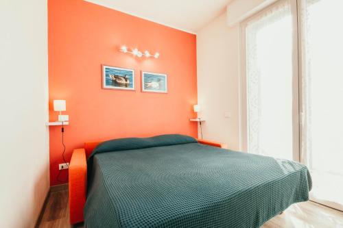 um quarto com uma parede laranja e uma cama em AL 13 Rosso - Lakeside Leisure & Business em Stresa
