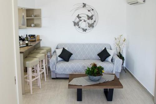 ein Wohnzimmer mit einem Sofa und einem Tisch in der Unterkunft Helen Superior Suite in Lindos