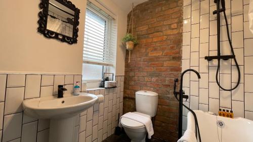 Un baño con lavabo, inodoro y ducha. en Fully Serviced Three Bed House in Durham, en Durham