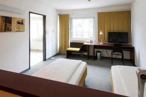 a bedroom with a bed and a desk with a computer at Kyriad Vienna Altmannsdorf in Vienna