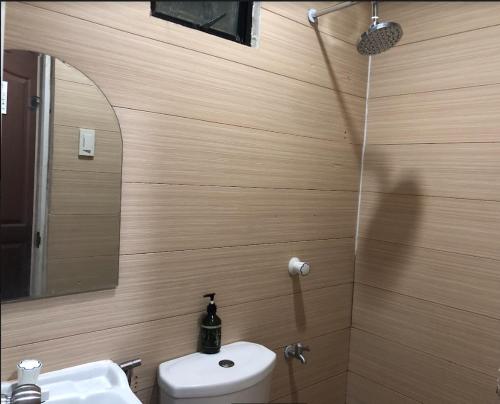 a bathroom with a toilet and a sink and a mirror at Maine City Residences Leveriza in Manila