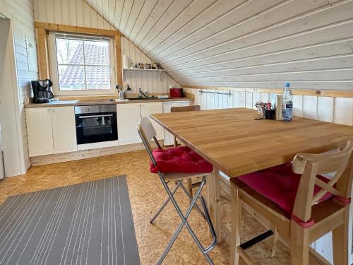 cocina con mesa de madera y sillas en Apartments im Schwedenstil, en Papenburg