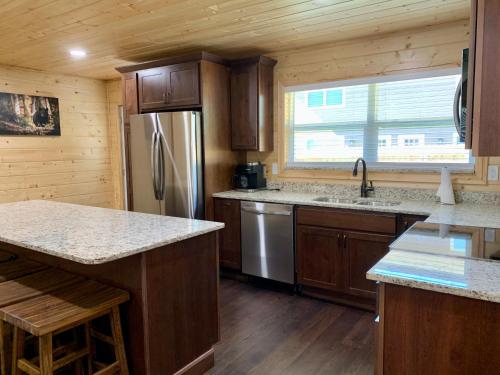 a kitchen with wooden cabinets and a stainless steel refrigerator at The Brick House: Brand NEW! 3 Bedroom Home with private driveway in Pigeon Forge