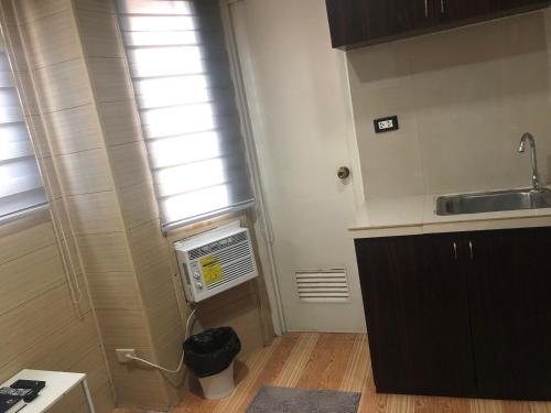 a small kitchen with a sink and a window at Maine City Residences Leveriza in Manila