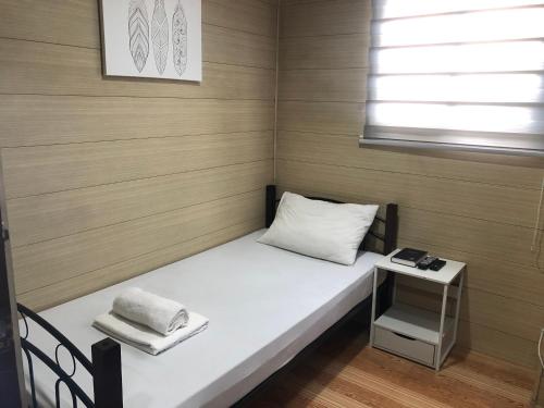 Habitación pequeña con cama y mesa en Maine City Residences Leveriza, en Manila
