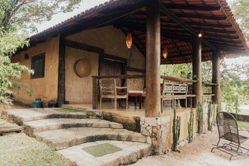 uma casa com uma mesa e cadeiras em frente em Baguá Bangalôs em Alto Paraíso de Goiás