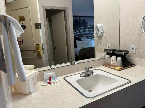 a bathroom with a sink and a mirror at Super 8 by Wyndham Lethbridge in Lethbridge