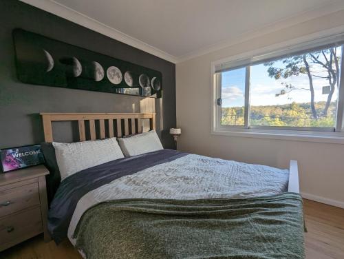 Un dormitorio con una cama grande y una ventana en Lunar Escape, en Glenbrook
