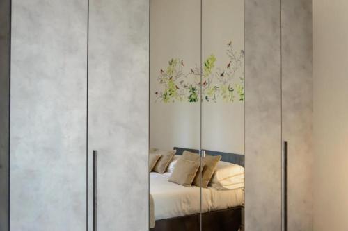 1 dormitorio con cama y armario con espejo en Homelink Firenze - Charlotte en Florencia