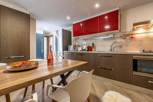 a kitchen with a wooden table and some chairs at [Lusso e relax] con piscina a 2 minuti dal mare in Miami Platja