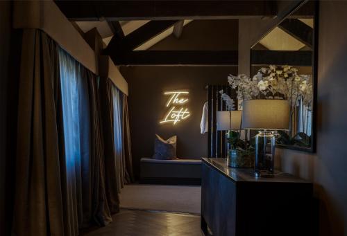 a room with a table with a lamp and a mirror at Derwent Manor Boutique Hotel in Consett