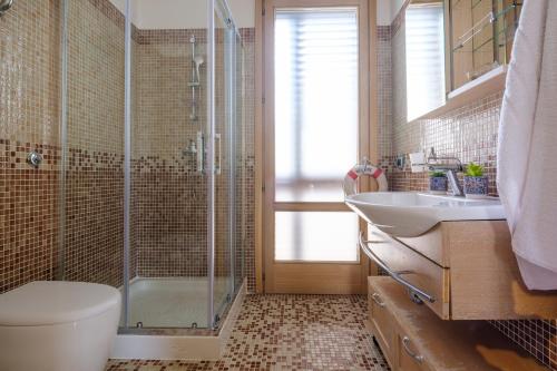 a bathroom with a shower and a toilet and a sink at Affaccio Sul Mare Luxury Home in Porto Cesareo